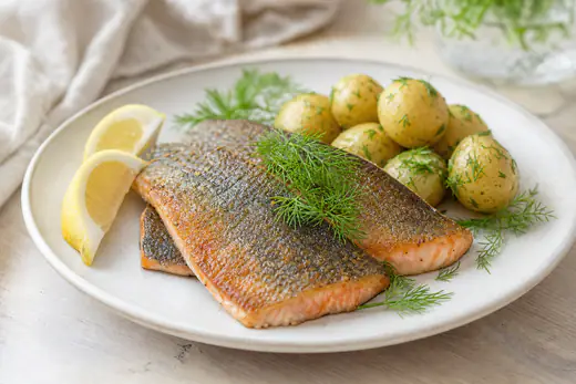 Stekt ørretfilet med sprø hud og rosa kjøtt, servert med sitronbåter, dill og kokte poteter