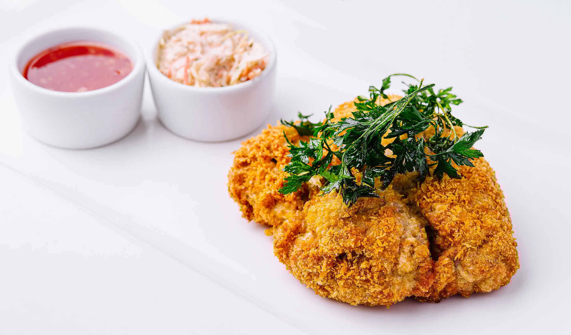 Sprø kyllingschnitzel tilberedt i airfryer, servert med sitron og salat.
