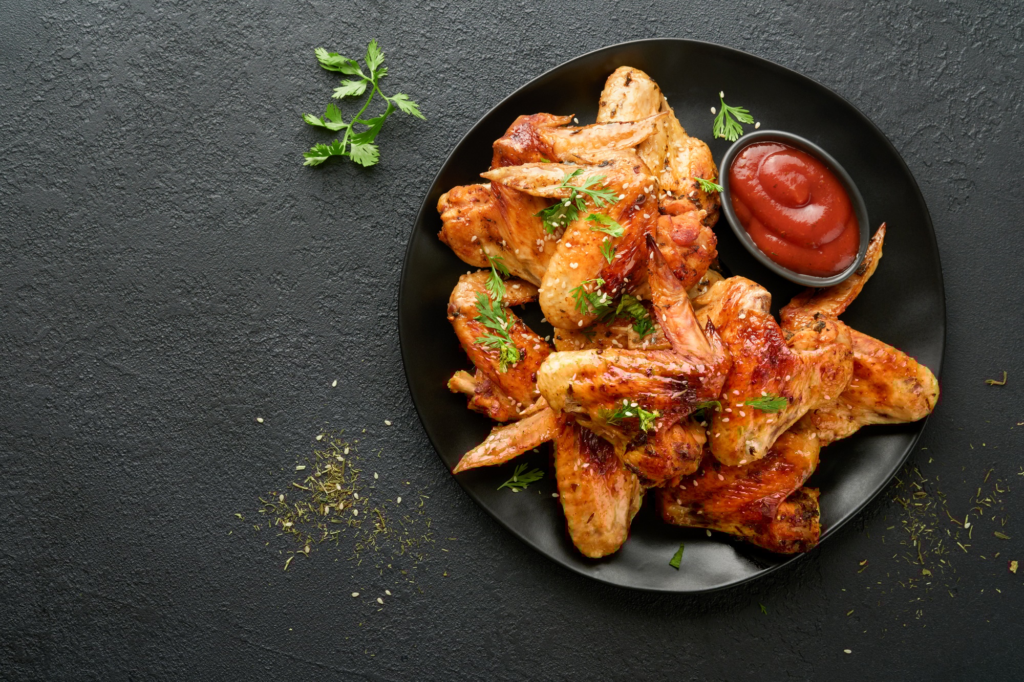 Sprø kyllingvinger laget i airfryer, servert med dipp og grønnsaker.