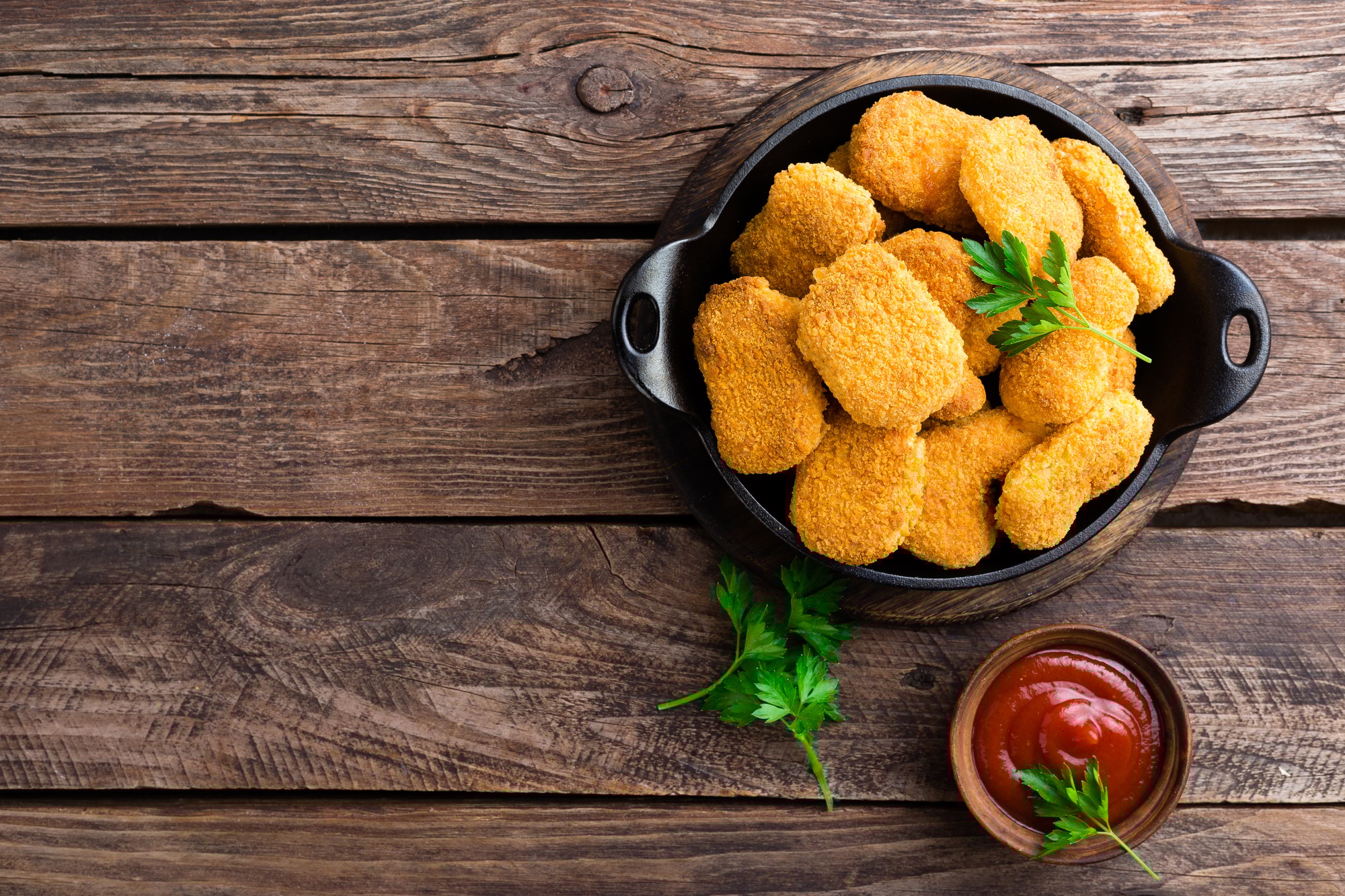 Sprø kyllingnuggets tilberedt i airfryer, servert med sauser.